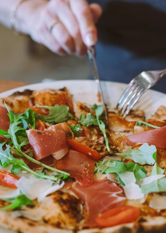 a person cutting a pizza with a knife and fork, offering a plate of food, award - winning crisp details ”