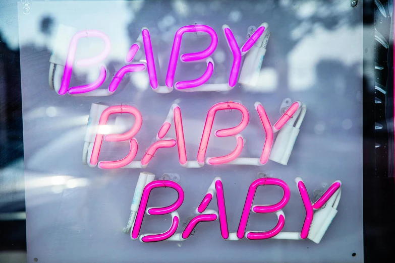 a baby sign in the window of a store, by Gwen Barnard, pixabay, neon standup bar, babe, pink studio lighting, fatherly