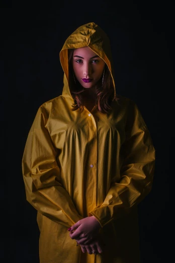 a woman in a yellow raincoat posing for a picture, unsplash, hyperrealism, on black background, paul barson, f / 2 0, hooded