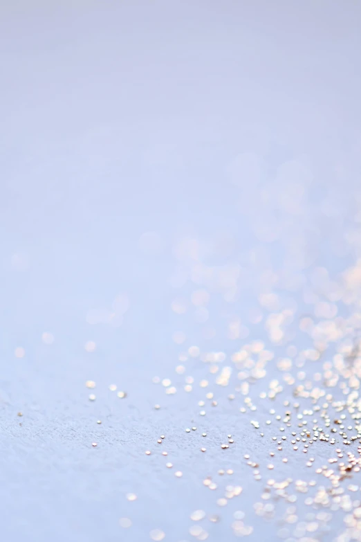 a small bird standing on top of a sandy beach, a microscopic photo, by Adam Marczyński, minimalism, ethereal bubbles, silver and sapphire, bokeh photograph, light-blue