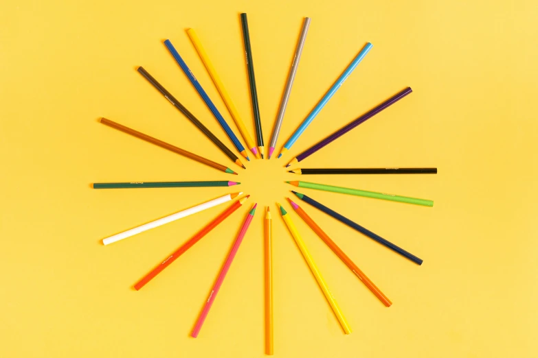 colored pencils arranged in a circle on a yellow background, by Carey Morris, 16 colors, sunburst, color ( sony a 7 r iv, brown