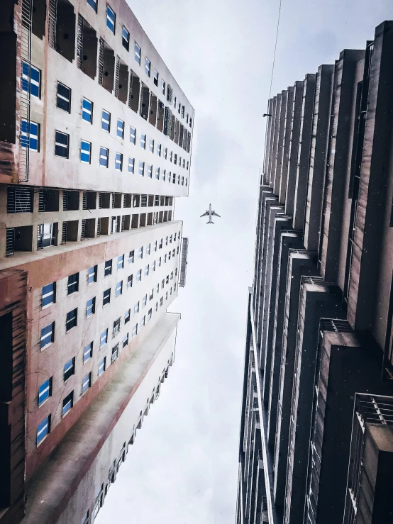 a couple of tall buildings next to each other, by Matt Stewart, pexels contest winner, airplane, instagram picture, prize winning color photo, multiple stories