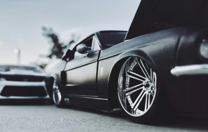 a couple of cars parked next to each other, unsplash, photorealism, highly detailed wheels, metal chrome, toy photo, wide body