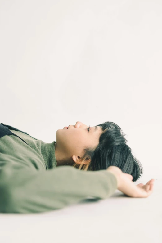 a woman laying on the ground next to a cat, by Ai-Mitsu, unsplash, visual art, plain background, sui ishida with black hair, as she looks up at the ceiling, androgynous person