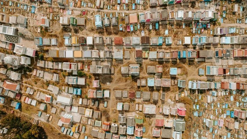 a large group of houses sitting on top of a hill, by Daniel Lieske, trending on unsplash, conceptual art, shanty town, top down view, giant grave structures, each land is a different color