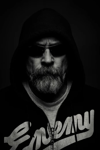 a black and white photo of a man in a hoodie, a black and white photo, by Tadeusz Makowski, unsplash, digital art, mark hamill, white beard, biker, william gibson