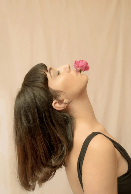 a woman with a flower in her mouth, an album cover, trending on pexels, photoshoot for skincare brand, seen from the side, yael shelbia, body and head in view