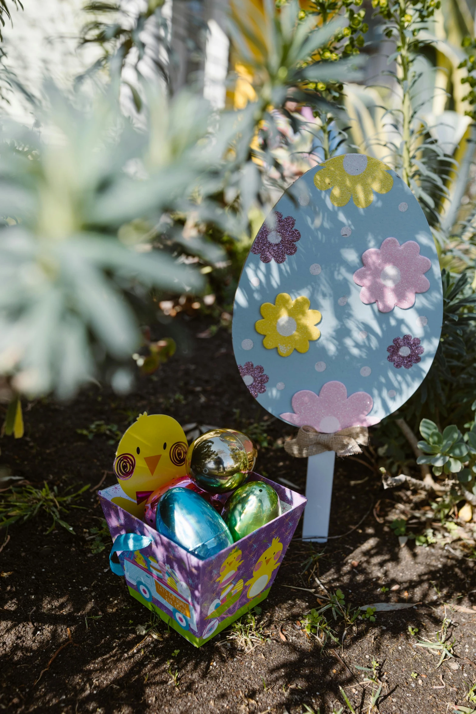 a basket filled with easter eggs under a tree, inspired by Eden Box, cut out of cardboard, looking towards camera, tag, with small object details