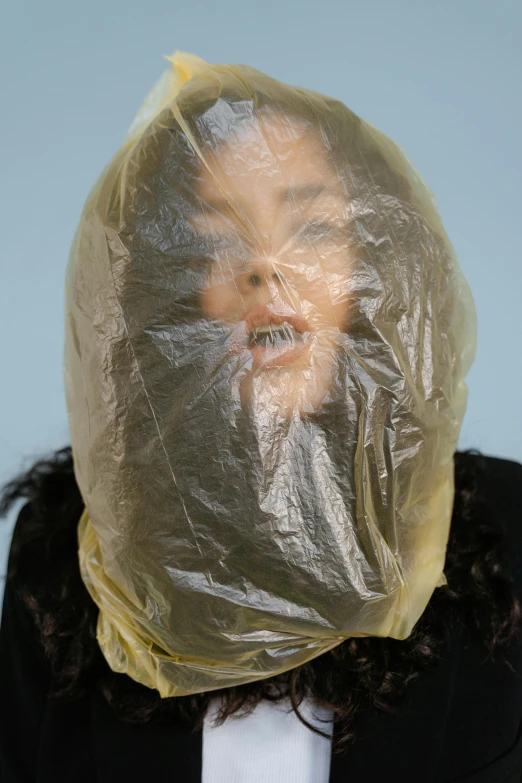 a woman with a plastic head covering her face, an album cover, inspired by Sarah Lucas, plasticien, containment pod, dezeen, wearing a plastic garbage bag, close up at face