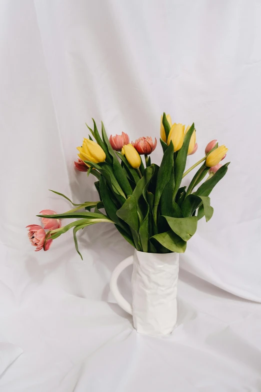 a white vase filled with pink and yellow flowers, inspired by François Boquet, unsplash, tulips, made of glazed, mix, full product shot