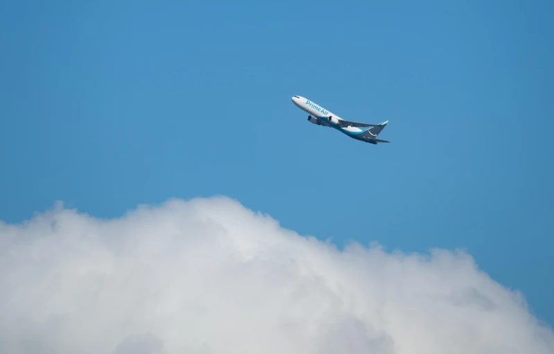 a large jetliner flying through a blue sky, by Derek Hill, pexels contest winner, minimalism, turquoise, on clouds, avatar image, concert