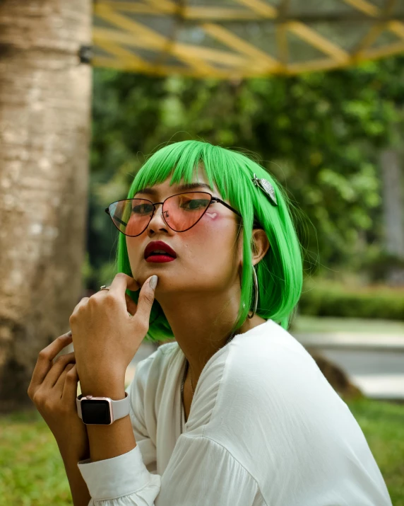 a woman with green hair smoking a cigarette, trending on pexels, lgbt, indonesia, small square glasses, with index finger