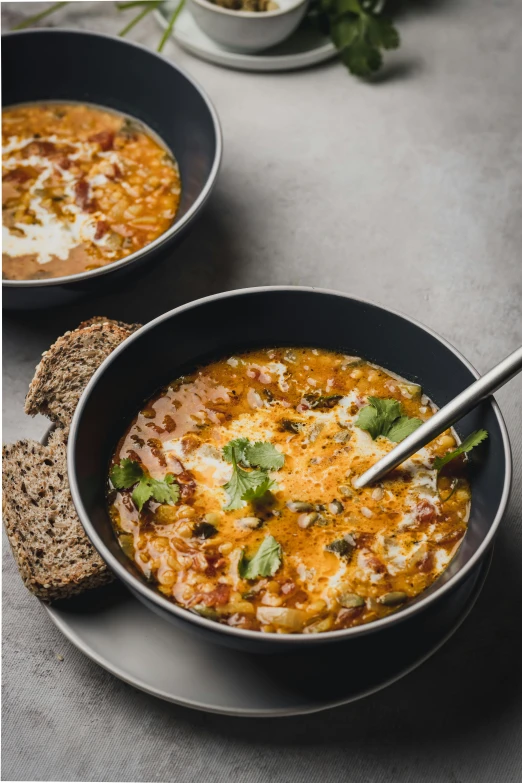 two bowls of soup sitting on top of a table, product image, on a dark background, hearty breakfast, speckled