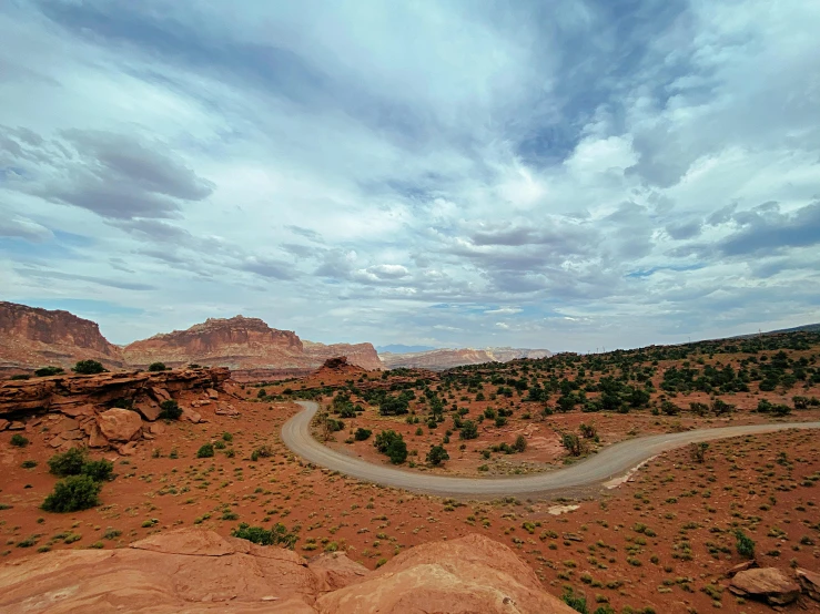 a winding road in the desert under a cloudy sky, unsplash contest winner, photorealism, moab, circuitry. 8k 3d geology, kodachrome colors, panoramic view