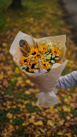 a little girl holding a bunch of flowers, by Lucia Peka, pexels contest winner, helianthus flowers, cardboard, autumnal colours, thumbnail