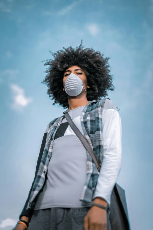 a man with a mask on his face, trending on pexels, afrofuturism, frizzy hair, sky blue, dressed in a gray, white wearing