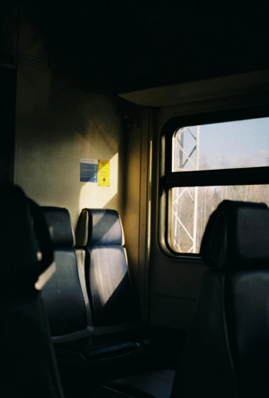 a couple of seats sitting next to each other on a train, unsplash, sun glare, multiple stories, eerie back light, vehicle
