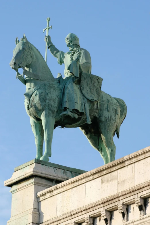 a statue of a man on a horse on top of a building, on a pedestal