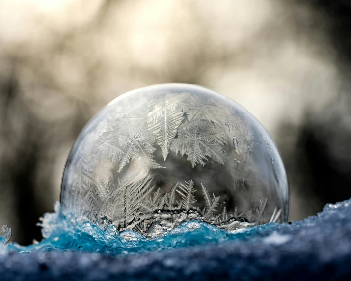 a snow globe sitting on top of a pile of snow, by Adam Marczyński, pexels contest winner, conceptual art, ice crystals, soap bubble, inside a marble, photo of a dyson sphere
