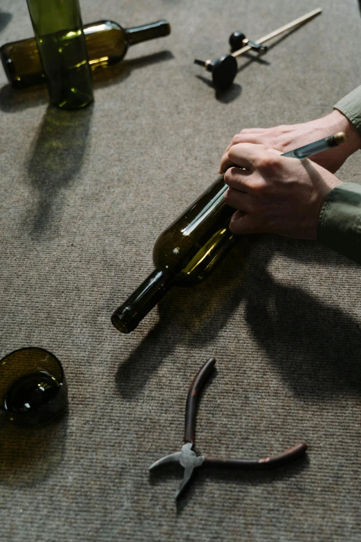 a person that is holding a bottle of wine, by Jakob Emanuel Handmann, pexels contest winner, process art, lying scattered across an empty, repairing the other one, insisted on cutting in line, tournament