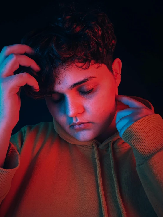 a close up of a person holding a cell phone, an album cover, inspired by Elsa Bleda, trending on pexels, overweight!! teenage boy, looking sad, lgbt, red colored