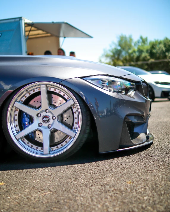 a close up of a car parked in a parking lot, by Adam Marczyński, tuning, wheel, profile image