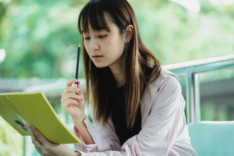 a woman sitting on a bench reading a book, a cartoon, trending on pexels, academic art, portrait of a japanese teen, holding pencil, looking from shoulder, standing in class