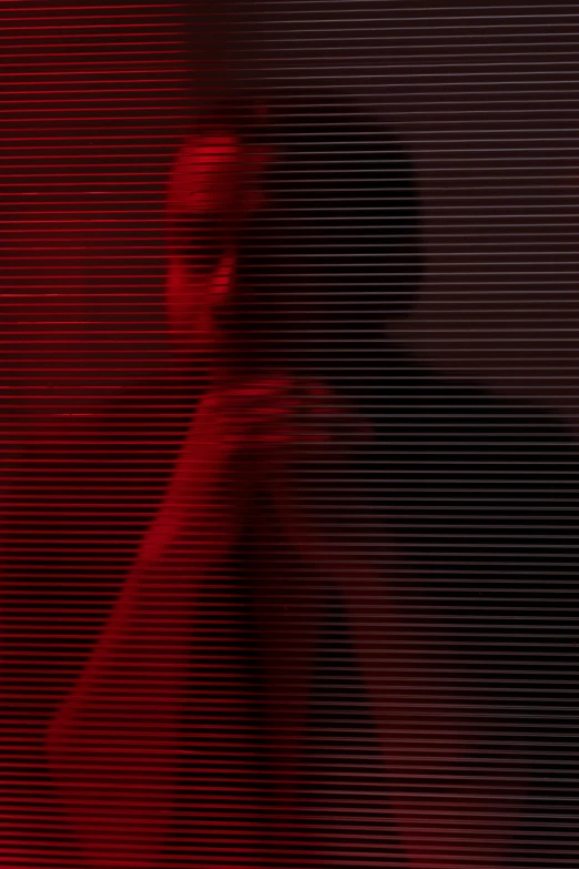 a woman standing in front of a red screen, inspired by Elsa Bleda, pexels contest winner, digital art, dark skinned, yeezus, grainy footage, man sitting facing away