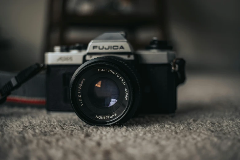 a camera sitting on top of a carpeted floor, a picture, unsplash contest winner, photorealism, fujicolor superia, tight focus, f11 aperture, cute photograph