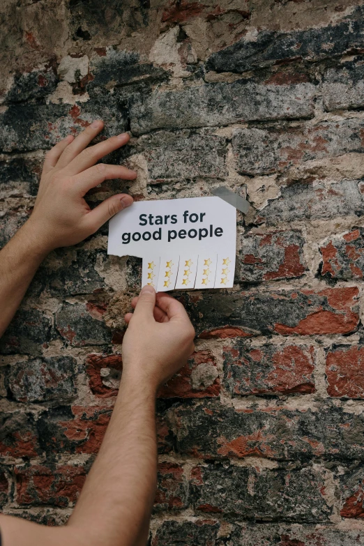 a person holding a sign that says stars for good people, an album cover, pexels contest winner, bricks, sticker, kacper niepokolczycki, teaser