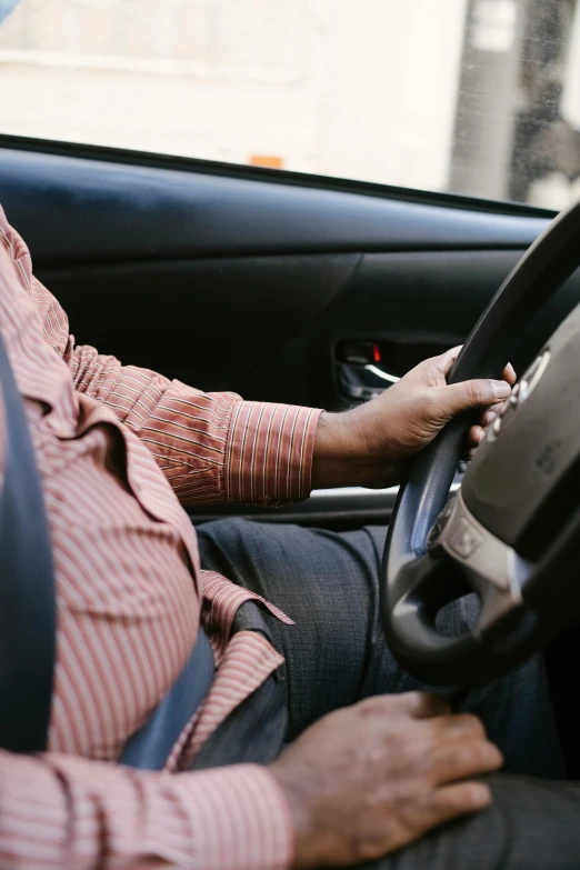 a man sitting in the driver's seat of a car, pexels, square, insanely inflated hips, slightly overweight, performance