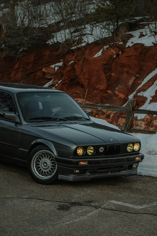 a black car parked on the side of the road, unsplash contest winner, renaissance, bmw e 3 0, profile image, in the hillside, front lighting