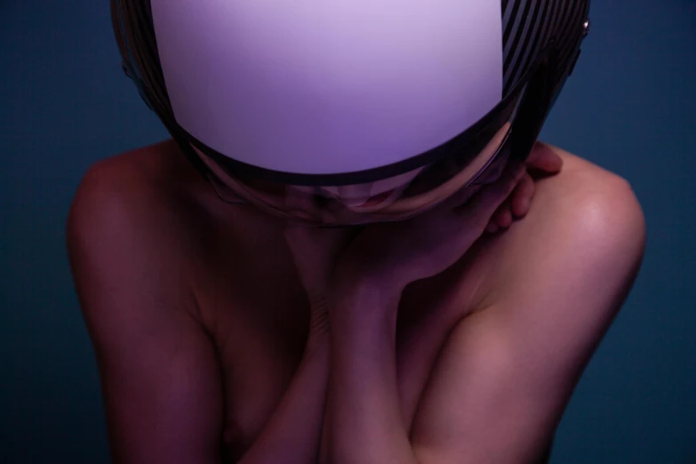 a woman holding her head in front of her face, an album cover, inspired by Gottfried Helnwein, unsplash, hyperrealism, motorcycle helmet, purple ambient light, karim rashid, sitting down