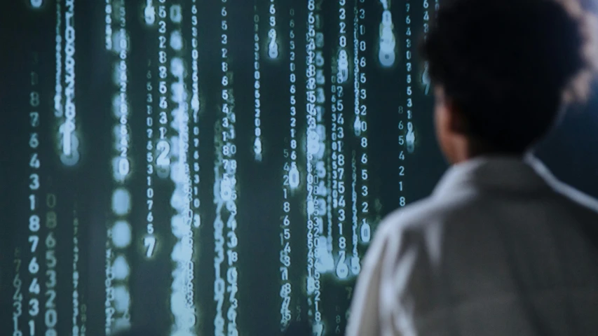 a man standing in front of a computer screen, a digital rendering, inspired by Ryoji Ikeda, unsplash, ascii art, movie still from the matrix, holographic runes, from scene from inception, digital arts