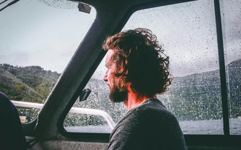 a man sitting in a boat looking out the window, wavy hair, instagram photo, sean mcloughlin, road trip