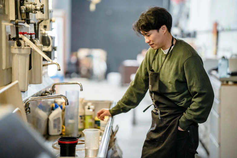 a man standing in a kitchen next to a sink, by Jang Seung-eop, aussie baristas, working in the forge, thumbnail, coffee smell