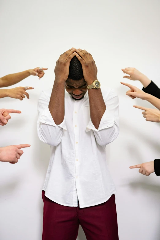a group of people pointing their fingers at a man in a white shirt, trending on pexels, facepalm, black man, head exploding, depressing image