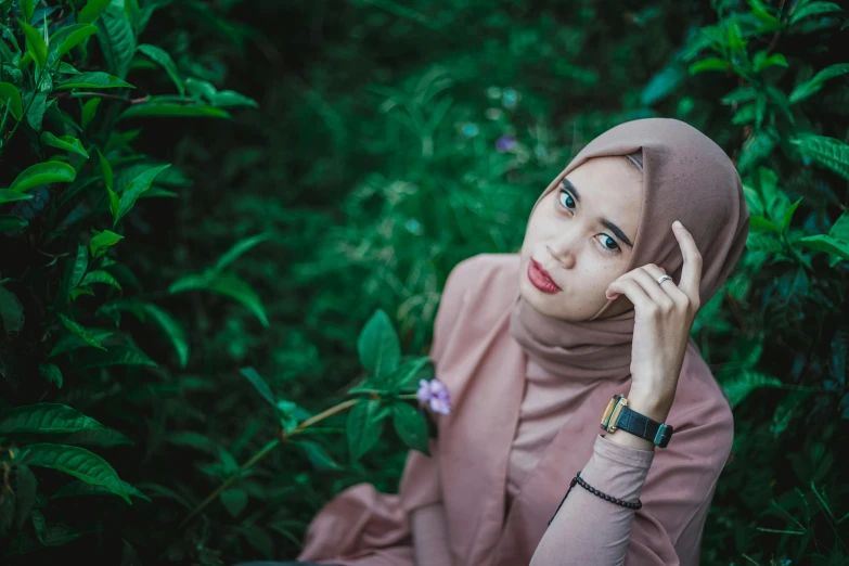 a woman wearing a hijab sitting in the grass, pexels contest winner, hurufiyya, with brown skin, young asian woman, 🤤 girl portrait, simple stylized