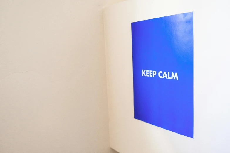 a book with the words keep calm written on it, a poster, inspired by Yves Klein, unsplash, interactive art, installation view, dezeen showroom, low - angle shot, large screen