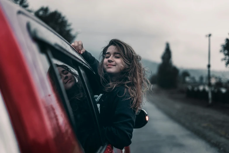 a woman leaning out the window of a car, pexels contest winner, happening, smiling girl, avatar image, girl standing, candid photo
