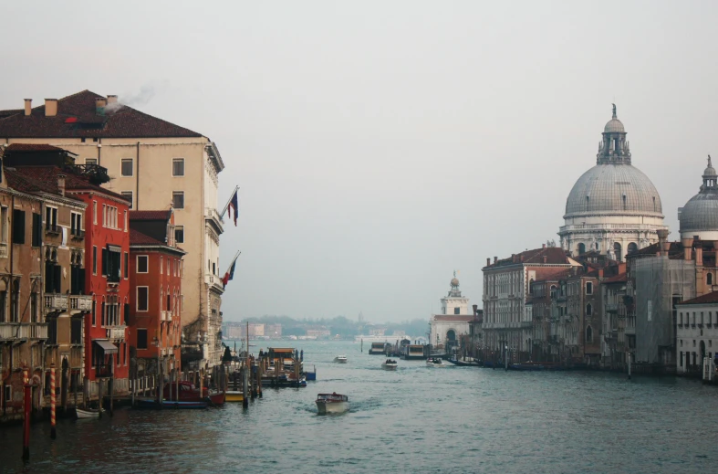 a canal filled with lots of boats next to tall buildings, a photo, inspired by Canaletto, pexels contest winner, renaissance, venice biennale's golden lion, foggy water, pink marble building, 2000s photo