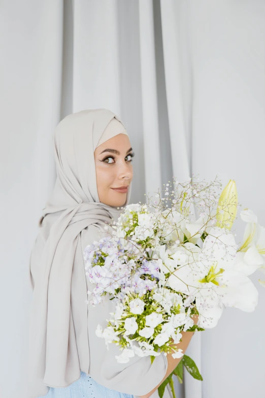 a woman in a hijab holding a bouquet of flowers, light grey, curated collection, fully covered, taupe