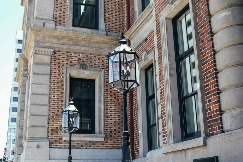 a street light in front of a brick building, a photo, unsplash, arts and crafts movement, gas lanterns, official courthouse, steel window mullions, over-shoulder shot