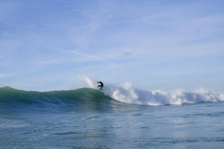 a man riding a wave on top of a surfboard, by Peter Churcher, pexels contest winner, figuration libre, cornwall, clear blue skies, jumping, natural morning light