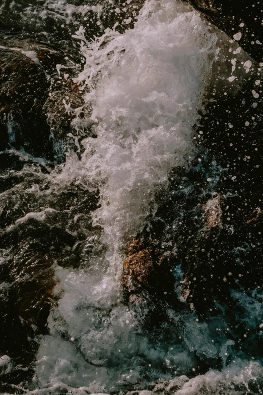 a man riding a surfboard on top of a wave, an album cover, trending on unsplash, waterfall in asteroid field, texture, high angle close up shot, water bubbles