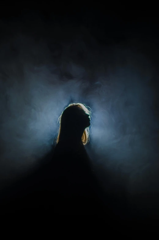 a silhouette of a woman in the dark, an album cover, pexels contest winner, light and space, blue fog, dramatic light 8 k, scary portrait, dark negative space