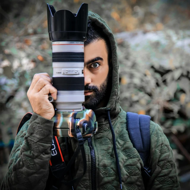 a man holding a camera up to his face, a picture, by Ismail Acar, pexels contest winner, photorealism, a portrait of rahul kohli, 6 0 mm lens in full armor, headshot profile picture, wide lense
