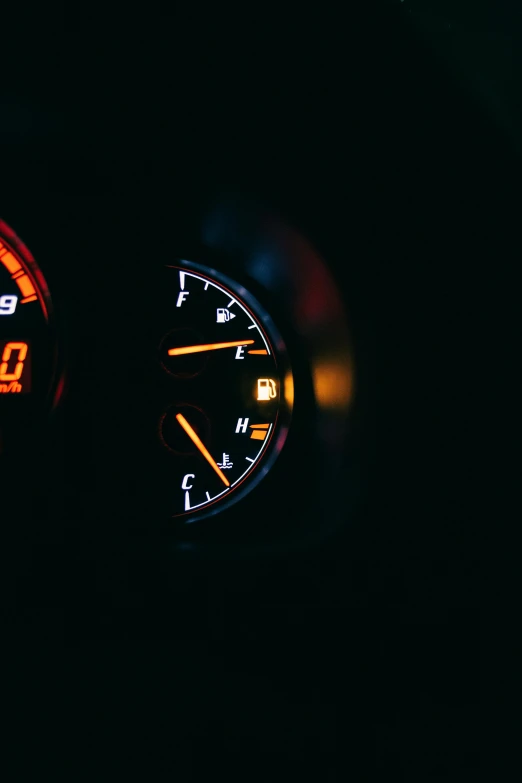 a close up of a speedometer in a car, by Matt Cavotta, unsplash, orange neon backlighting, gasoline engine, with a black background, instagram post