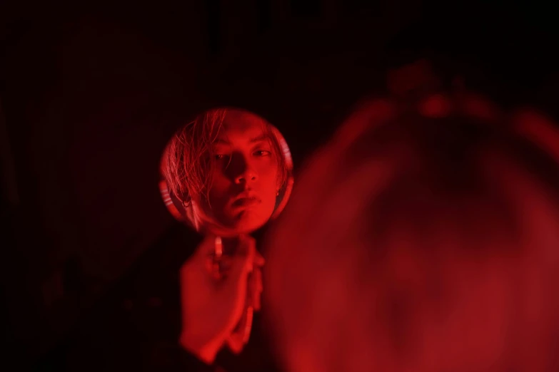 a woman looking at her reflection in a mirror, an album cover, by Adam Marczyński, pexels contest winner, volumetric lighting. red, johan liebert mixed with dante, shot on red camera, scene from live action movie