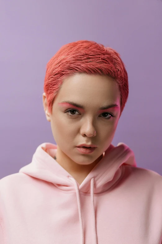 a woman with pink hair wearing a pink hoodie, an album cover, inspired by Elsa Bleda, trending on pexels, pixie cut, portrait sophie mudd, cgsociety portrait, solid background